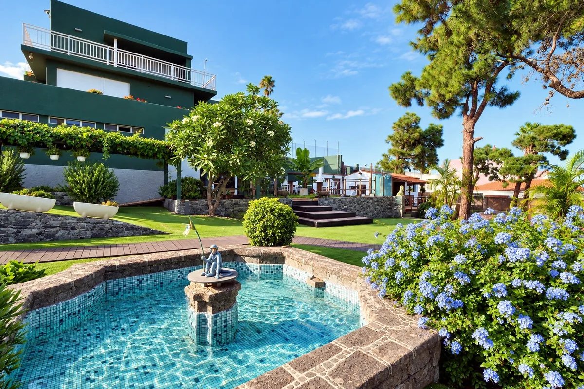 Jardín con fuente de Casa Amada y el edificio racionalista